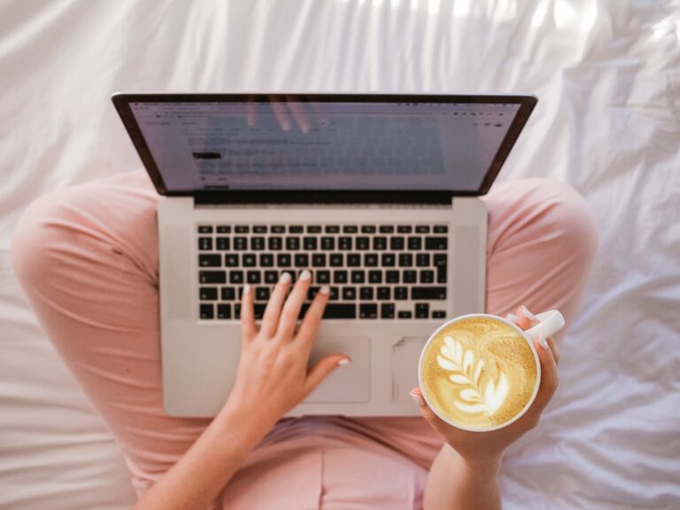 Blog schreiben: Anleitung für deinen ersten Beitrag Blog schreiben - Bloggerin schreibt einen Beitrag am Laptop mit Kaffee