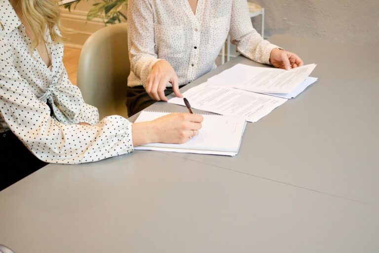 Gewerbe anmelden - Gründerin unterschreibt Unterlagen bei einer Beratung